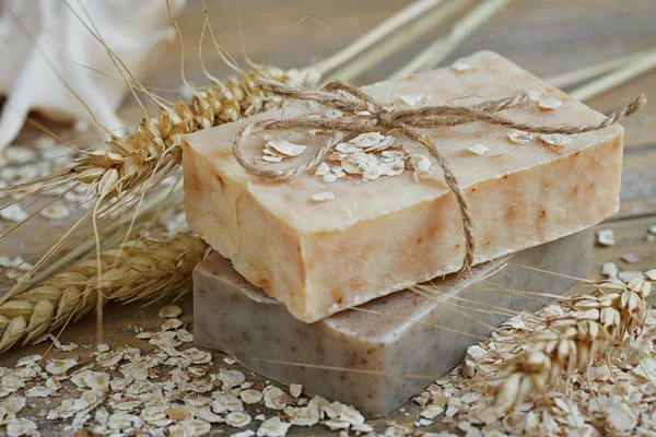 Natural handmade soap, oat flakes and wheat ears on wooden backg Stock Photo