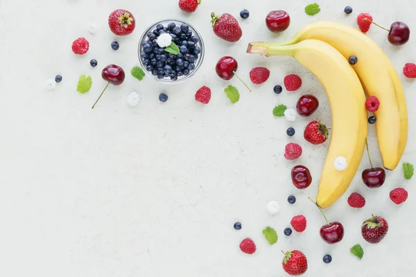 Ahududu, tatlı kiraz, muz ve bilberry Beyaz ahşap bac üzerinde