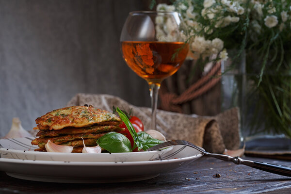 Vegetarian zucchini fritters served with fresh herbs, tomatoes a