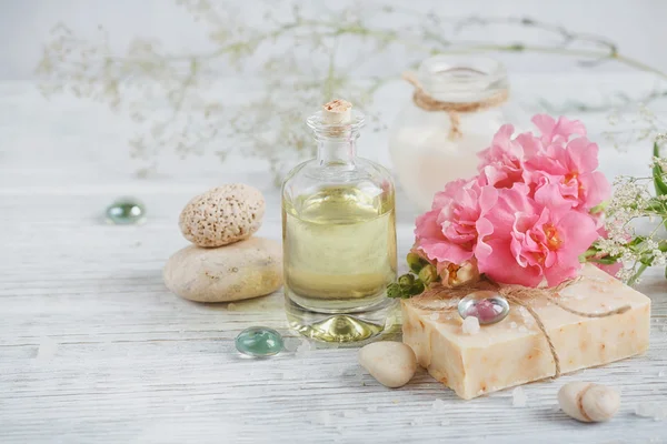Naturalne mydła ręcznie robione, olejki aromatyczne i kwiaty na biały drewniany — Zdjęcie stockowe
