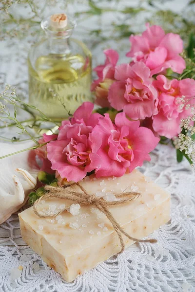 Натуральне мило ручної роботи, ароматична олія та квіти на білому дереві — стокове фото