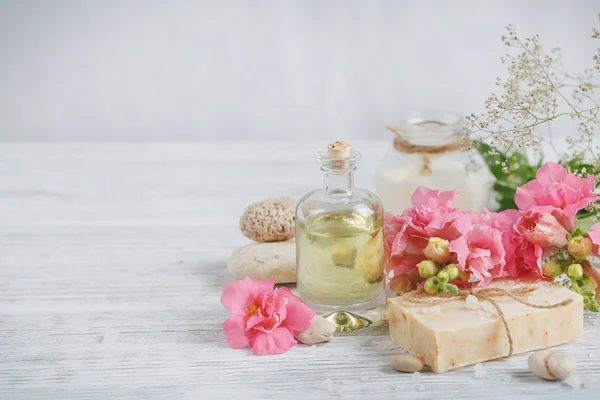 Natuurlijke, handgemaakte zeep, aromatische olie en bloemen op wit houten — Stockfoto