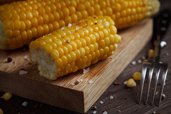 Golden corn cob with oil, herbs and salt on rustic wooden table — Stock Photo, Image