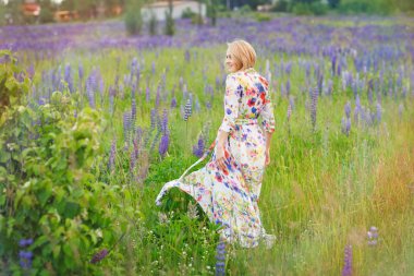 Bir çiçek alanda, dans ve yürüyüş genç güzel kadın yaz açık.