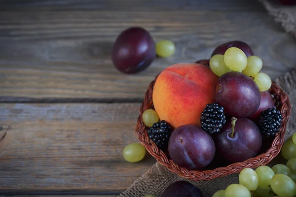 Суміш свіжих ягід і фруктів на сільському дерев'яному фоні — стокове фото