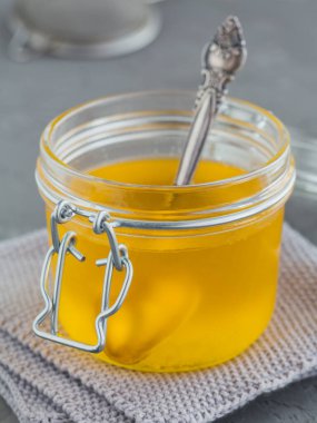 Ev yapımı Ghee ya da gri beton arka planda kavanozda tereyağı.