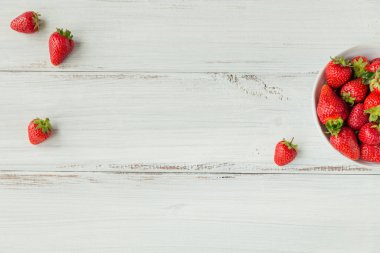 Beyaz arka planda seramik kasede taze çilek yığını. Sağlıklı beslenme ve diyet gıda kavramı.