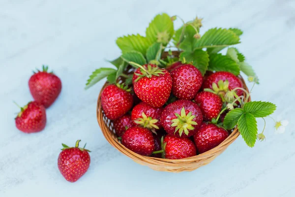 Montón de fresas frescas en un tazón de canasta sobre fondo de madera clara. Alimentación saludable y dieta concepto de alimentos. — Foto de Stock