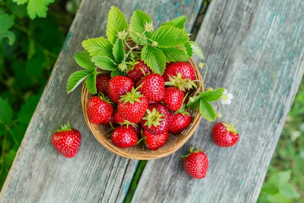 Un tazón de fresas rojas y jugosas sobre una mesa rústica de madera. Concepto de bocadillos saludables y dietéticos. — Foto de Stock