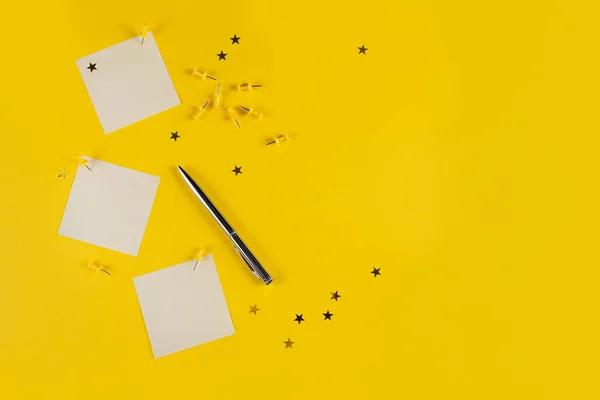 New year decoration of yellow office desk table with blank notebook and other office supplies. Top view with copy space, flat lay.