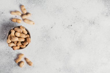 Fıstık yığını beyaz arka planda bir kasede. Kabuklarında taze fındık. Metin için boş alanı olan üst görünüm