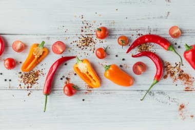 Beyaz ahşap masanda taze sıcak renkli biber, kiraz domatesleri ve baharatlar karışımı. Yemek pişirmek için baharatlar. Yemek pişirmek için baharat..