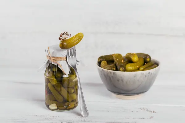 Preserving pickled cucumbers, seasonings and garlic on a white wooden table. Healthy fermented food. Home canned vegetables.