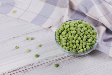 Bir kasedeki yeşil organik bezelyeler. Hızlı pişirme için ev yapımı hazırlıklar kavramı. Sağlıklı vejetaryen gıda konsepti