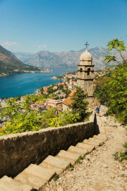 Kotor 'un eski kasabasındaki kilise, antik duvarlar, dağlar ve deniz manzarası. Karadağ, Kotor Körfezi. Üst görünüm