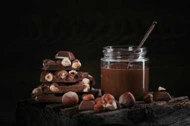 Ev yapımı çikolatalı fındıklı süt. Koyu ahşap arka planda cam kavanoza yayılmış.