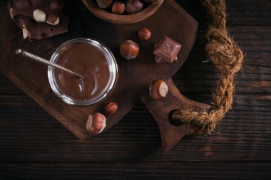 Ev yapımı çikolatalı fındıklı süt. Koyu ahşap arka planda cam kavanoza yayılmış.