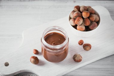 Ev yapımı çikolatalı fındıklı süt Beyaz ahşap arka planda yayılıyor