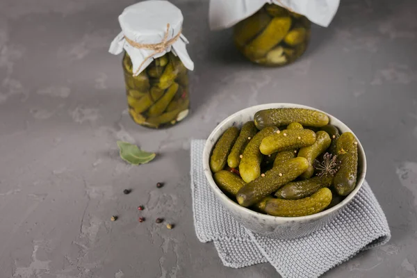 Preserving pickled cucumbers, seasonings and garlic on a grey concrete table. Healthy fermented food. Home canned vegetables.