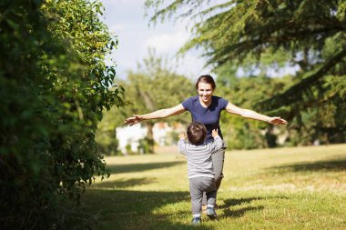 Anne ve küçük çocuk parkta oynuyorlar.