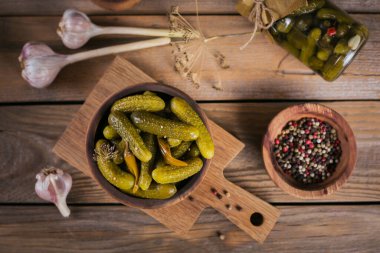Ahşap bir masada salatalık turşusu, baharat ve sarımsak. Sağlıklı mayalanmış yiyecek. Ev yapımı sebze konservesi.