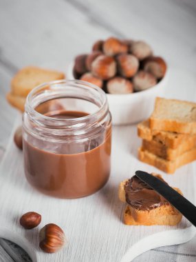 Beyaz ahşap arka planda kahvaltıda fındıklı çikolatalı tost.