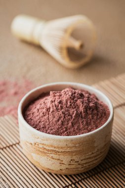 Bej arka planda Japon aletleriyle organik renk tozu çayı Matcha. Vejetaryen sağlıklı içeceği ve içeceği hesaba katın.