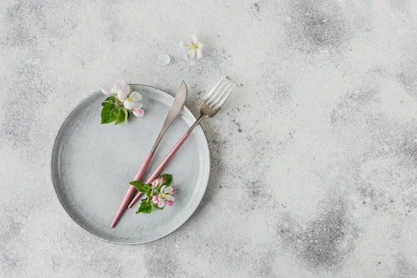 Prostírání stolu s kvetoucími jabloněmi větvemi a květy — Stock fotografie