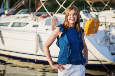 Güneşli bir yaz gününde marinada poz veren çekici bir kadın.