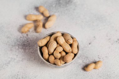 Fıstık yığını beyaz arka planda bir kasede. Kabuklarında taze fındık.