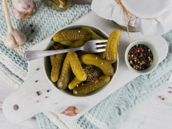 Preserving pickled cucumbers, seasonings and garlic on white wooden table