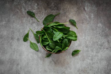 Bir kâsede taze ıspanak yaprakları. Koyu organik yeşil yaprakların üst görüntüsü. Sağlıklı vejetaryen yemek yaşam tarzı konsepti