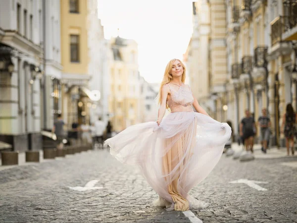 stock image Pretty smiling young woman with long blond hair in elegant flying light dress