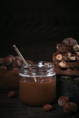 Ev yapımı çikolatalı fındıklı süt. Koyu bir arka plana yayılmış.