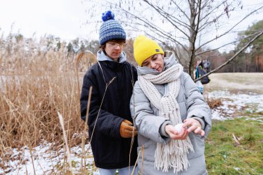 Anne, dışarıda sakin bir günün tadını çıkarırken başını oğullarının omzuna yasladığı duygusal aile anı.