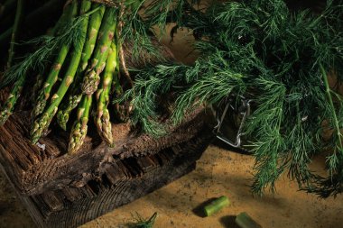 Mutfak sahnesi yeşil kuşkonmaz ve taze dereotlu ahşap ve şeffaf kavanozla