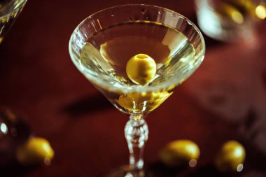 İçinde yeşil zeytinler ve lüks bir bar atmosferi olan klasik bir martini..