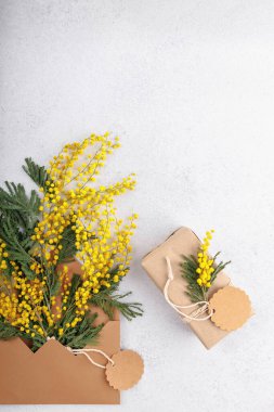 Bahar tatili arka planında mimoza buketi ve boş fiyat etiketli eko hediye ve kopyalama alanı
