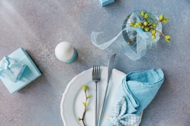 Paskalya temalı tabak, yumurta tutacağı, hediyeler ve yumuşacık mavi renkli vazo.