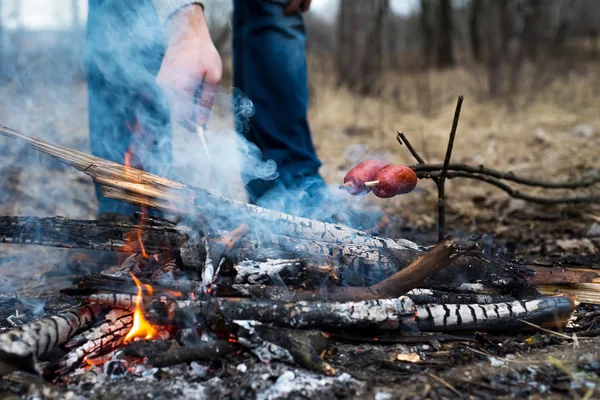 Embutidos en el palo a la parrilla en el fuego — Foto de Stock