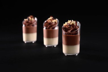 Katmanlı panna cotta köpüklü camlar siyah üzerine izole edilmiş..