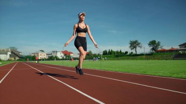 Atlayan atlet kadın atlama halatını açık havada kullanıyor..