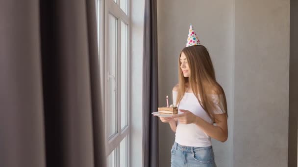 Cumpleaños mujer joven pidiendo deseo cerca de ventana. — Vídeo de stock