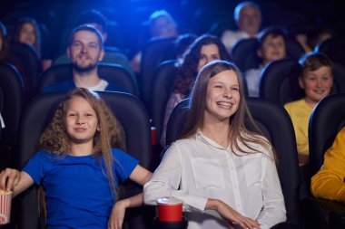 Küçük kız kardeşi sinemada gülen genç kız..