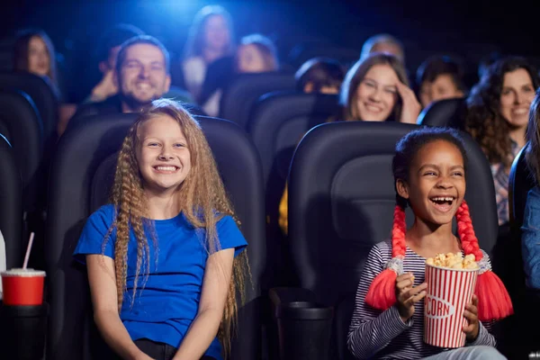 Мультирасовая аудитория, наслаждающаяся мультфильмом в кинозале. — стоковое фото