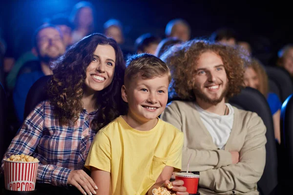 Щаслива сім'я з сином насолоджується мультфільмом у кінозалі . — стокове фото