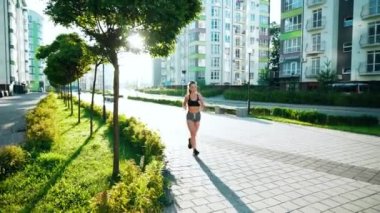 Ayakkabı bağcıklarını bankta bağlayan kadın koşucu.