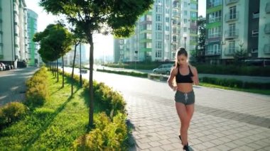 Sporcu kadın koşudan sonra bankta bacaklarını açıyor..