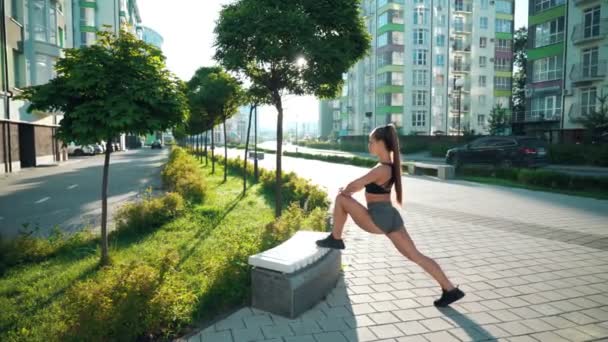 Fitnesswoman stretching gambe su panca all'aperto. — Video Stock