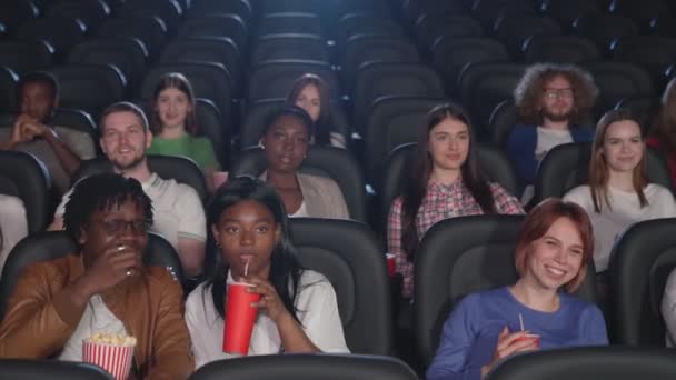 Wielorasowa publiczność oglądająca komedię w kinie. — Wideo stockowe